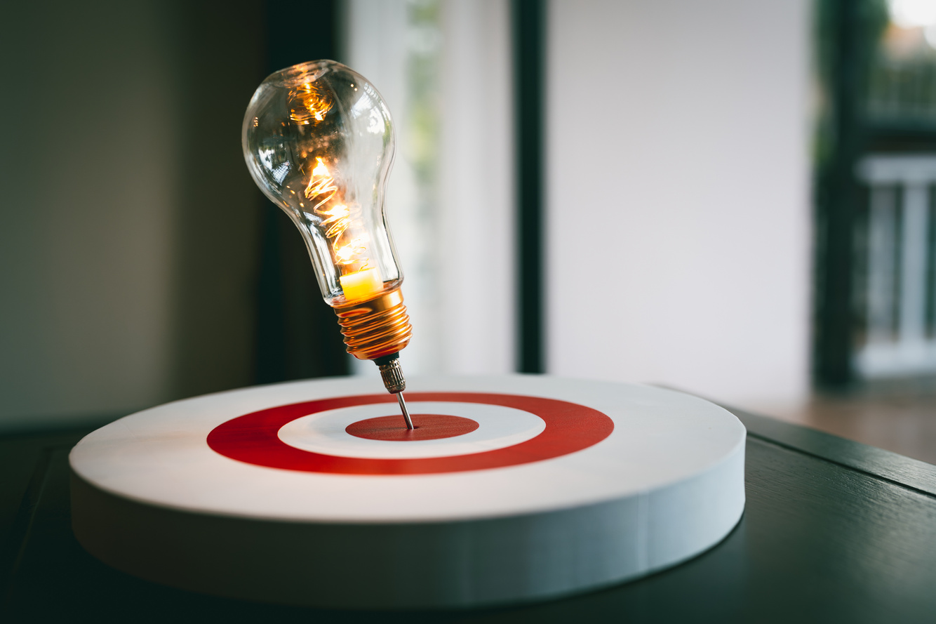 Light bulb with arrow of darts on dart board. Concept of finding problem solving or business development, key to success.